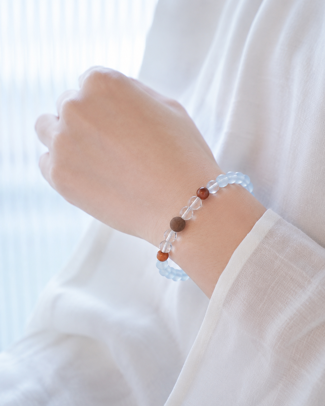 Side view of aquamarine and incense bracelet worn on wrist